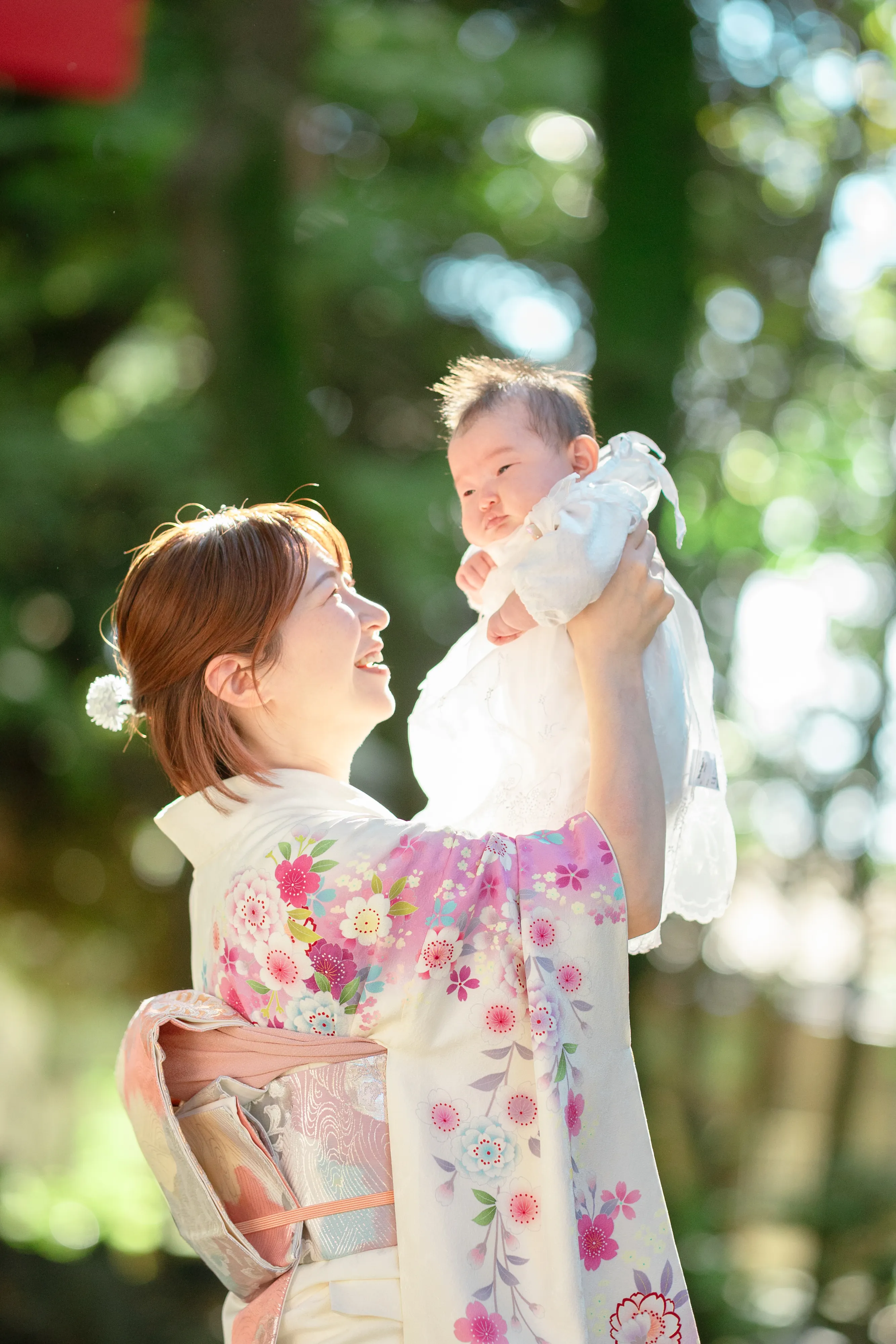 赤ちゃんを抱き上げて微笑む母親