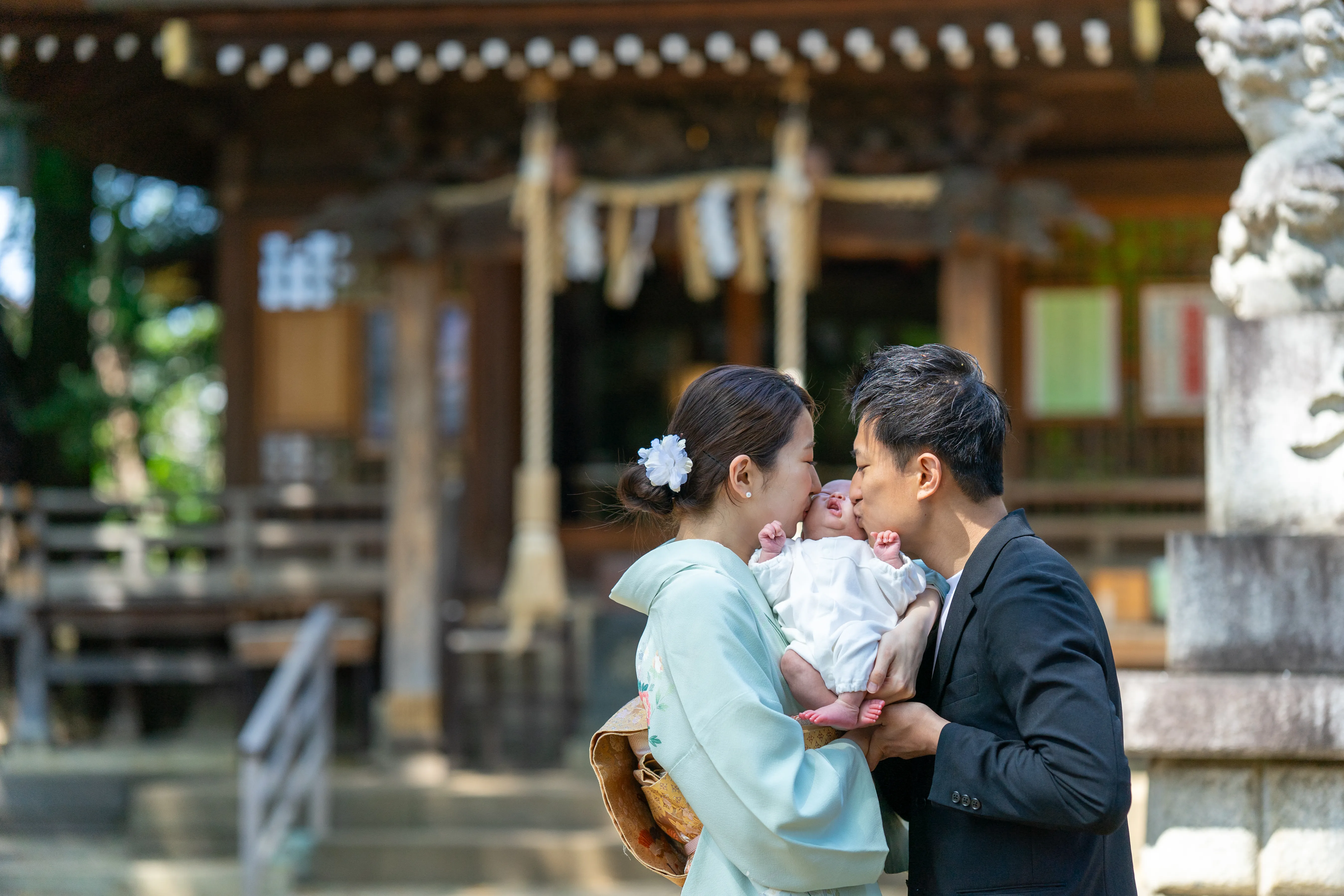 赤ちゃんの頬にキスをするご両親